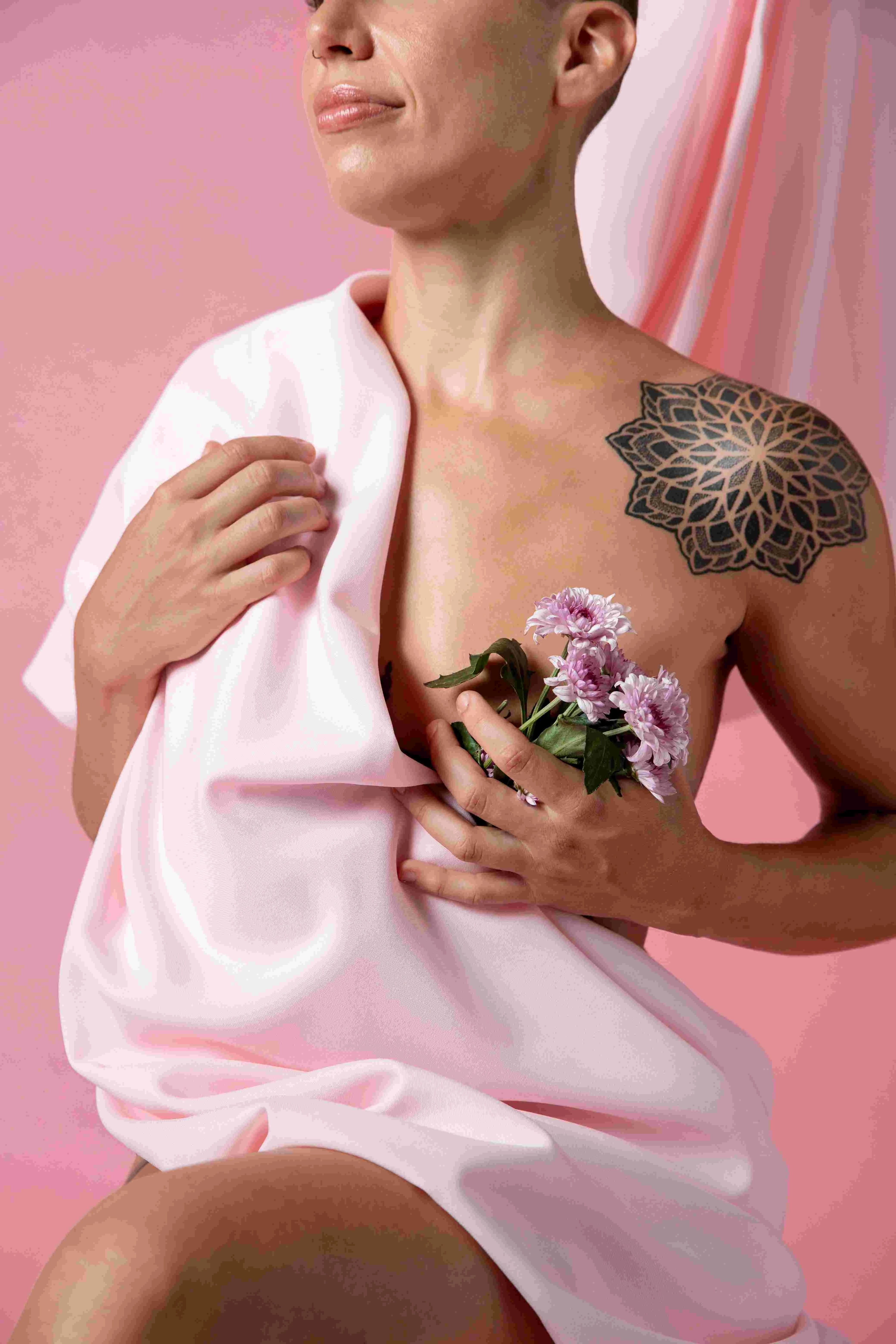 Femme tenant des fleurs roses et un tissu rose