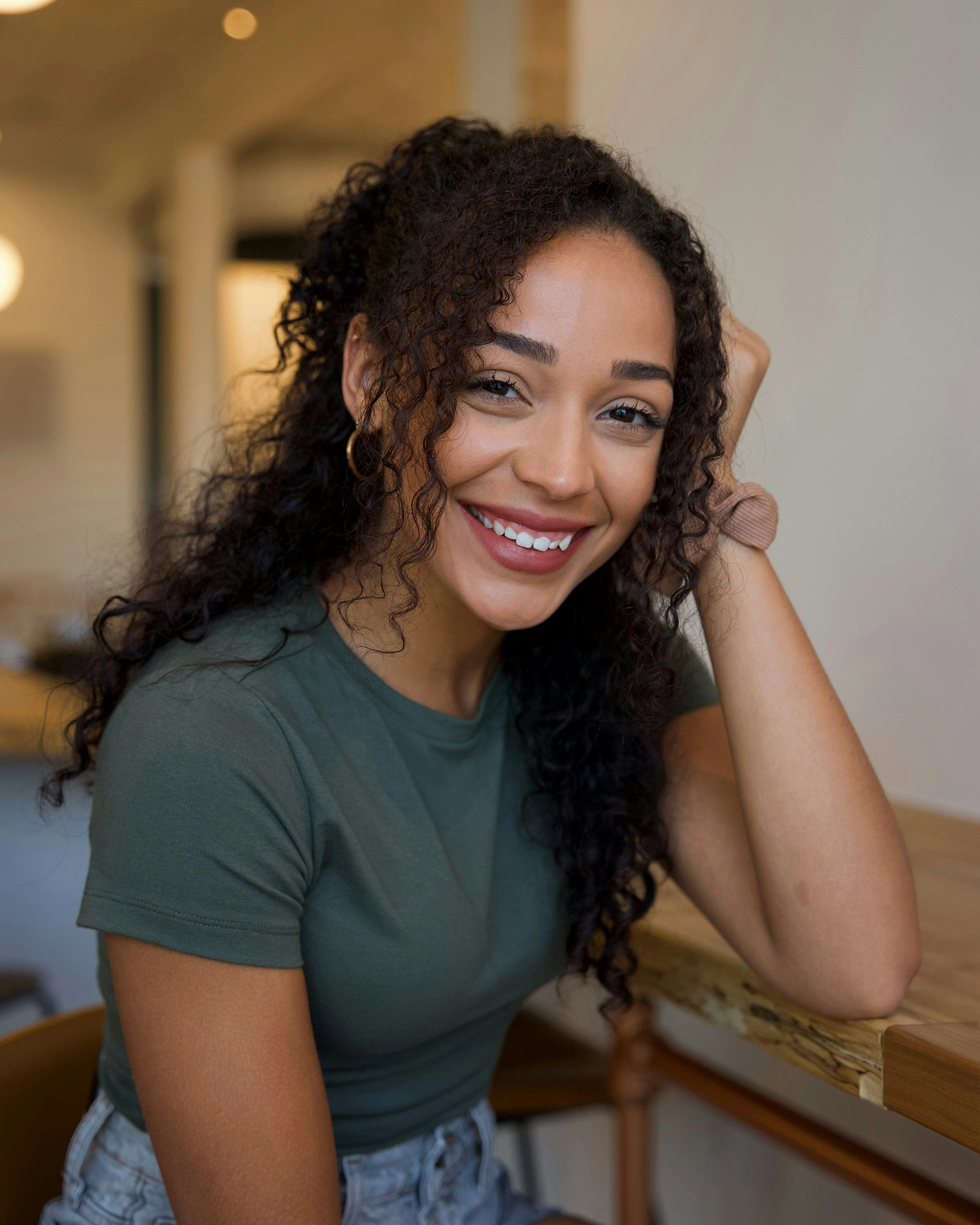 Femme souriante aux cheveux bouclés foncés