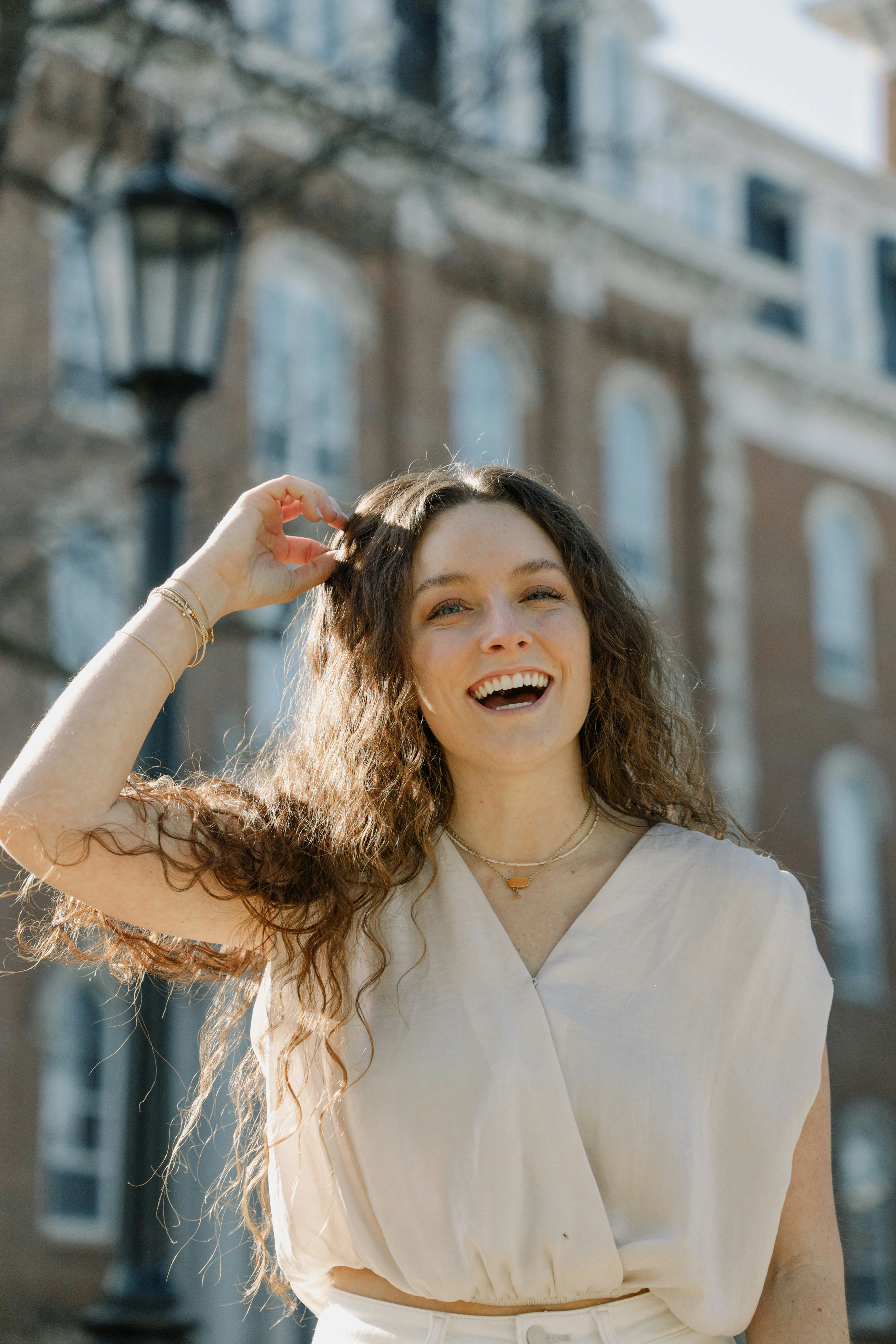 Femme souriante aux boucles brunes dans une rue