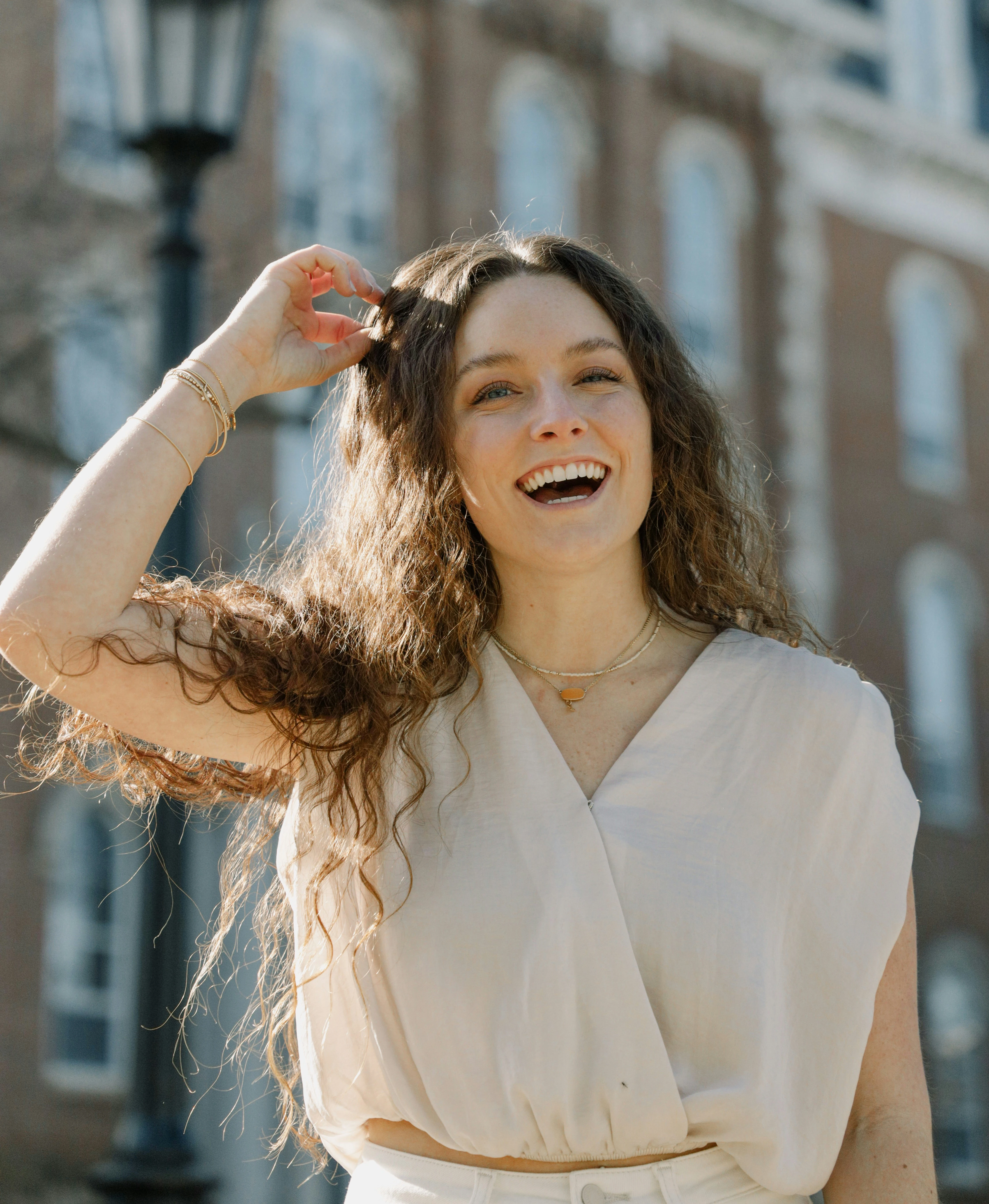 Femme souriante aux boucles brunes dans une rue
