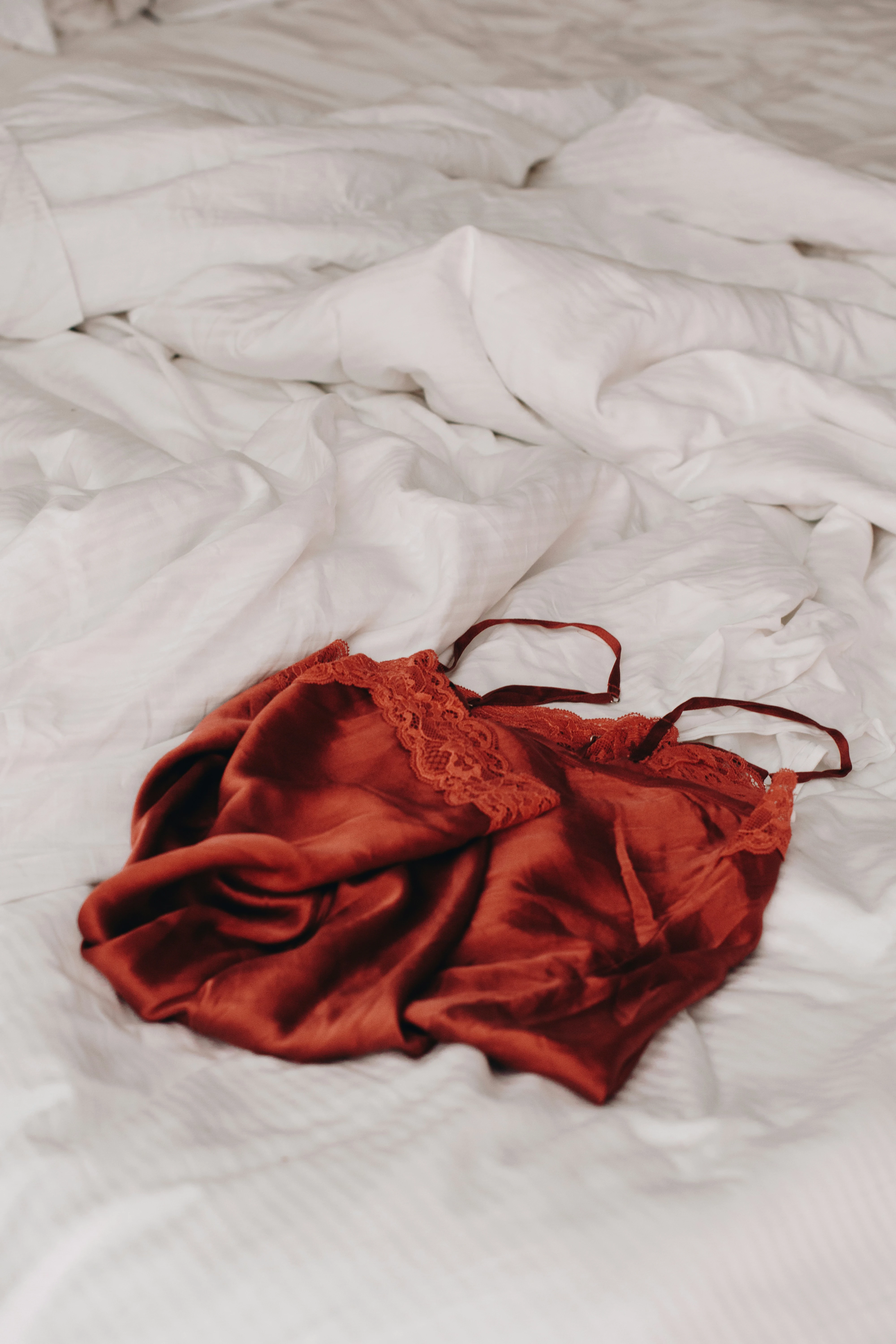 chemise rouge posée sur une couverture blanche
